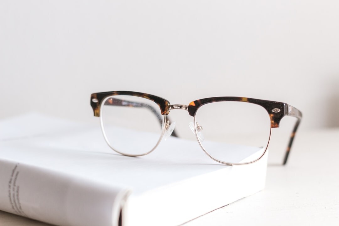 Elegant thin-framed prescription eyeglasses on a book