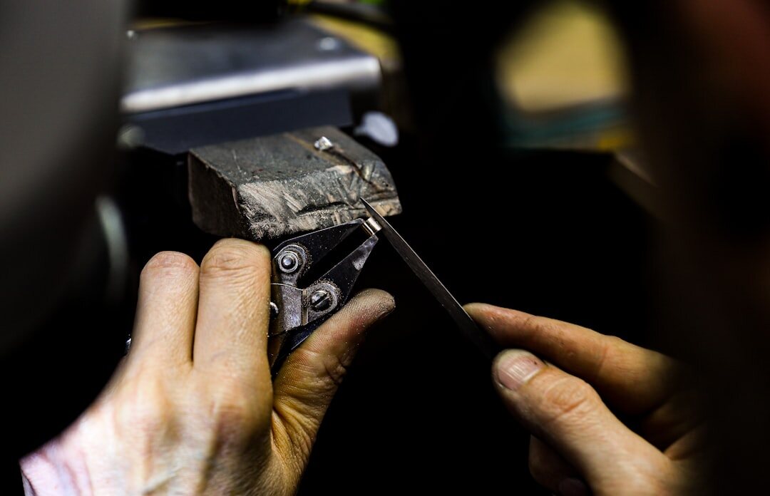 Craftsman's hands polishing a metal watch case component