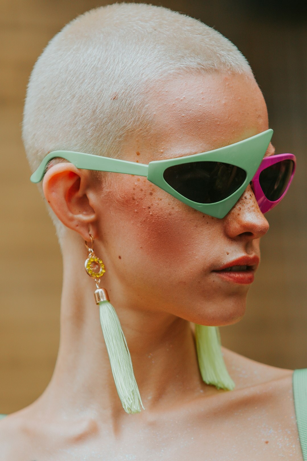 Pair of designer sunglasses with gold frame on light surface